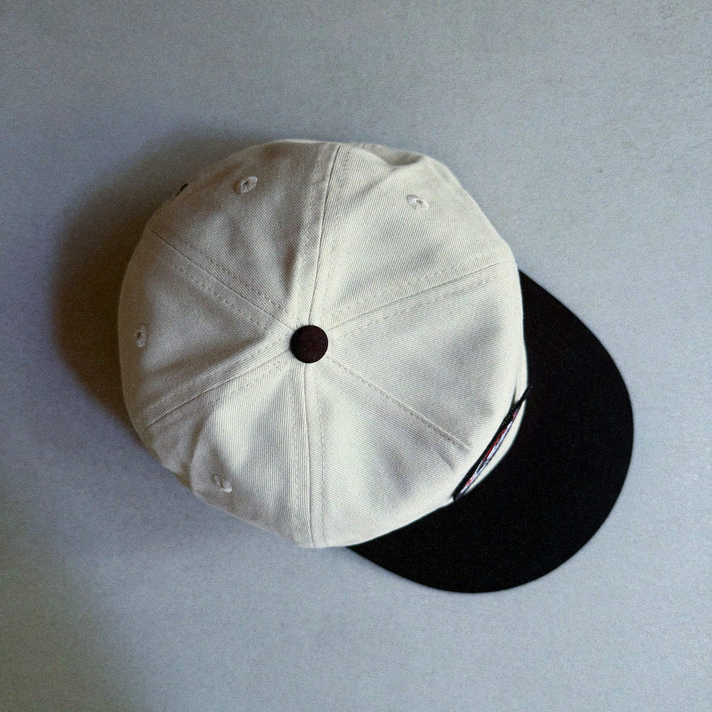 Two-tone natural and black cap with an embroidered patch featuring Oswald The Lucky Rabbit and the phrase 'Make Your Own Luck'