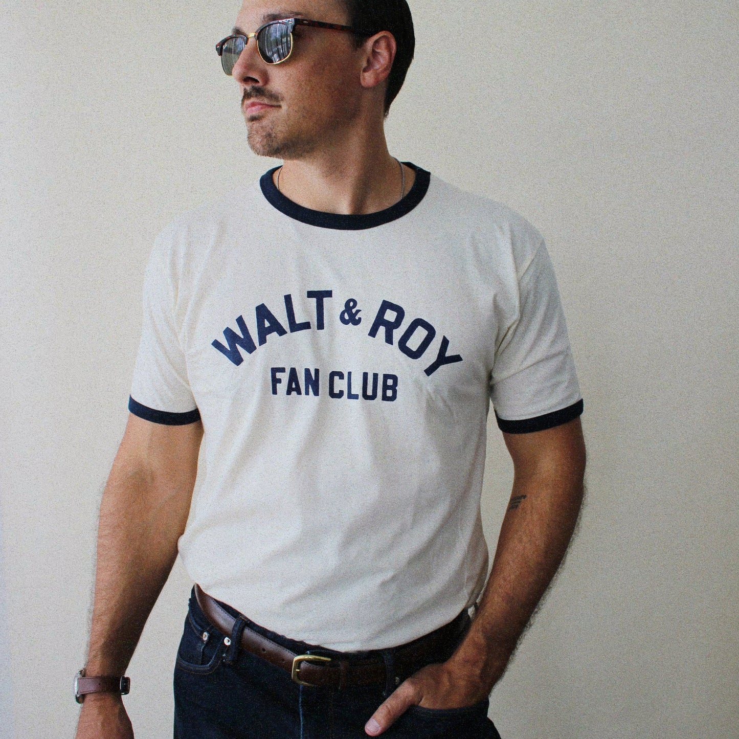 Man wearing a 'Walt & Roy Fan Club' t-shirt against a plain background