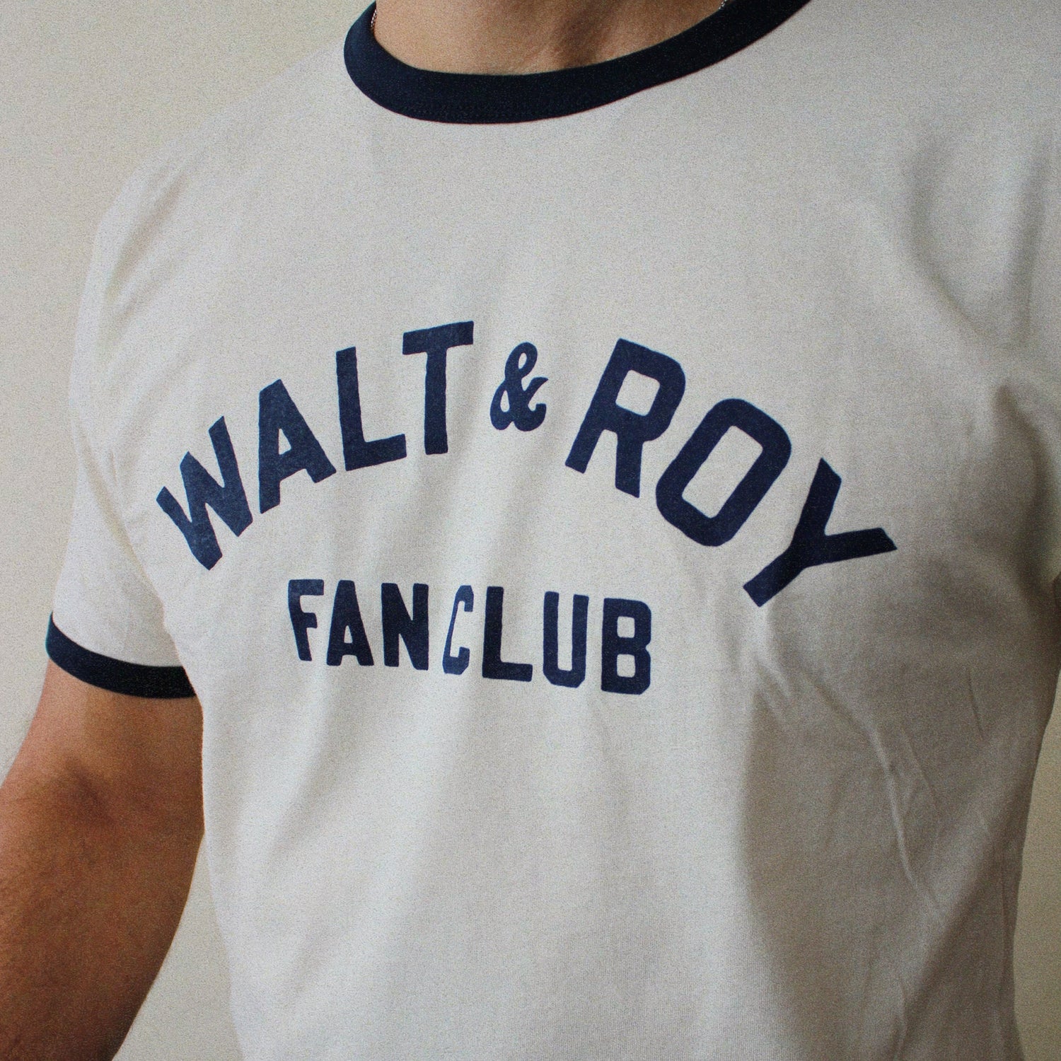 White t-shirt with 'WALT & ROY FANCLUB' text on a plain background