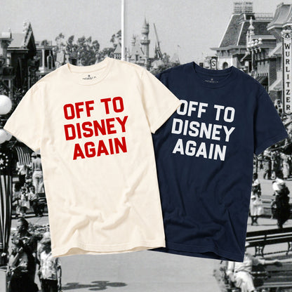 Two t-shirts with 'OFF TO DISNEY AGAIN' text, one ivory and one navy, against a blurred Disney theme park background.