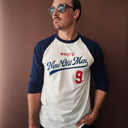 Man wearing the Nine Old Men baseball t-shirt with sunglasses against a brown background