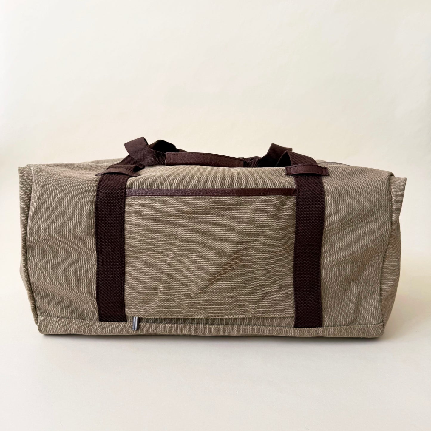beige disney duffel bag with brown straps on a white background