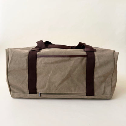 beige disney duffel bag with brown straps on a white background