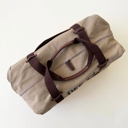 Beige Disney duffle bag with brown straps on a white background
